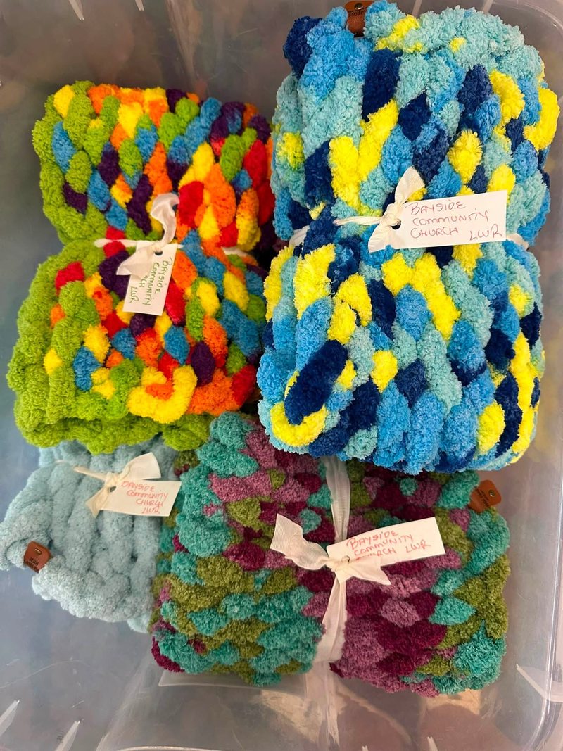 Colorful handmade blankets tied with ribbons and small notes